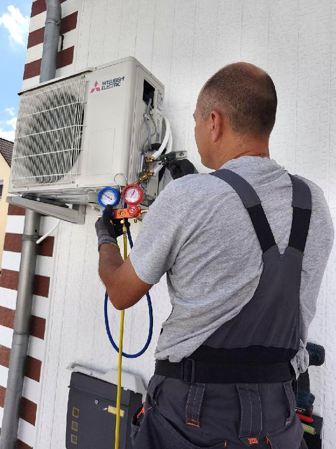 Techniker bei der Kontrolle einer Klimaanlage mit einem Manometer