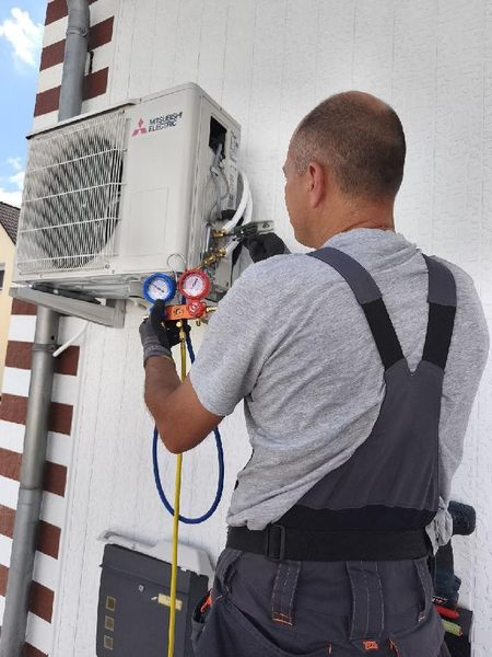Servicetechniker bei der Prüfung eines Klimageräts mit Manometer