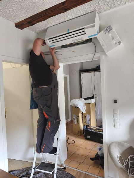 Monteur bei der Installation eines wandmontierten Klimageräts