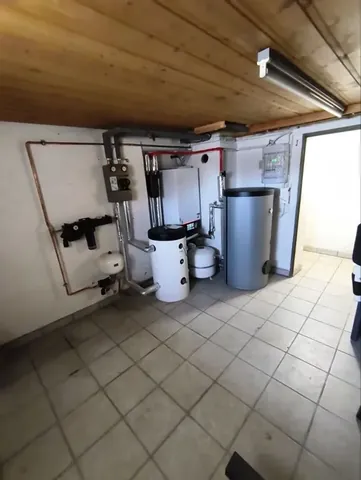 Technikraum mit Speicherbehältern und angeschlossenen Leitungen.